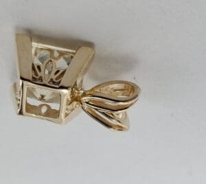 Gold pendant with intricate design details.