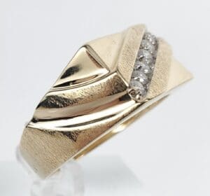 Gold ring with diamond accents on top.
