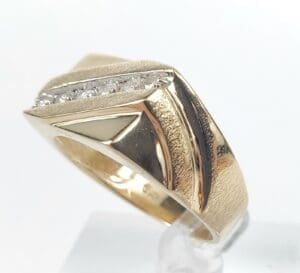Gold ring with diamonds on white background.