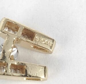 Gold jewelry piece with embedded clear stones.