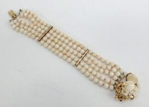 White beaded bracelet with floral clasp.