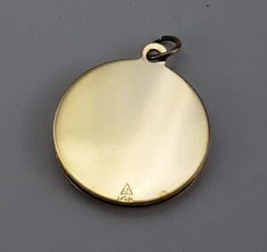 Gold round pendant with attached loop.