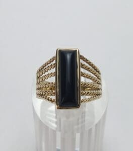 Gold ring with rectangular black stone.
