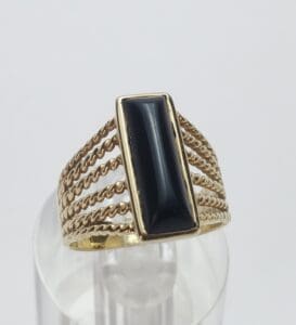 Gold ring with rectangular black stone.