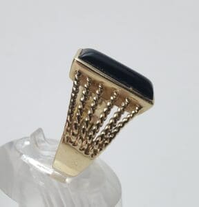 Gold ring with black rectangular stone.