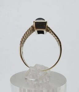 Gold ring with a black stone setting.