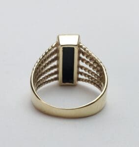 Gold ring with black rectangular stone.