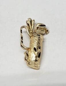 Gold golf bag brooch with clubs.