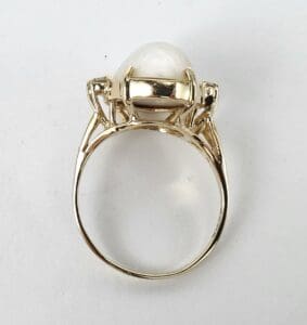 Gold ring with a large pearl setting.