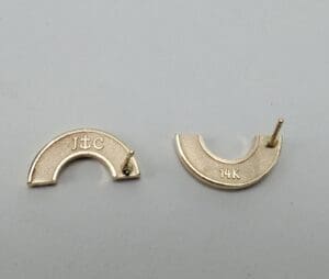 Two gold earring backs, labeled 14K.