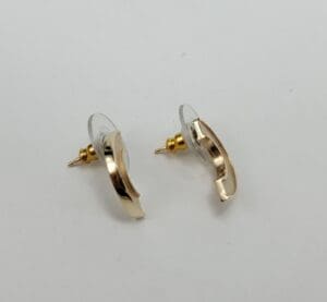 Gold crescent moon earrings on white background.