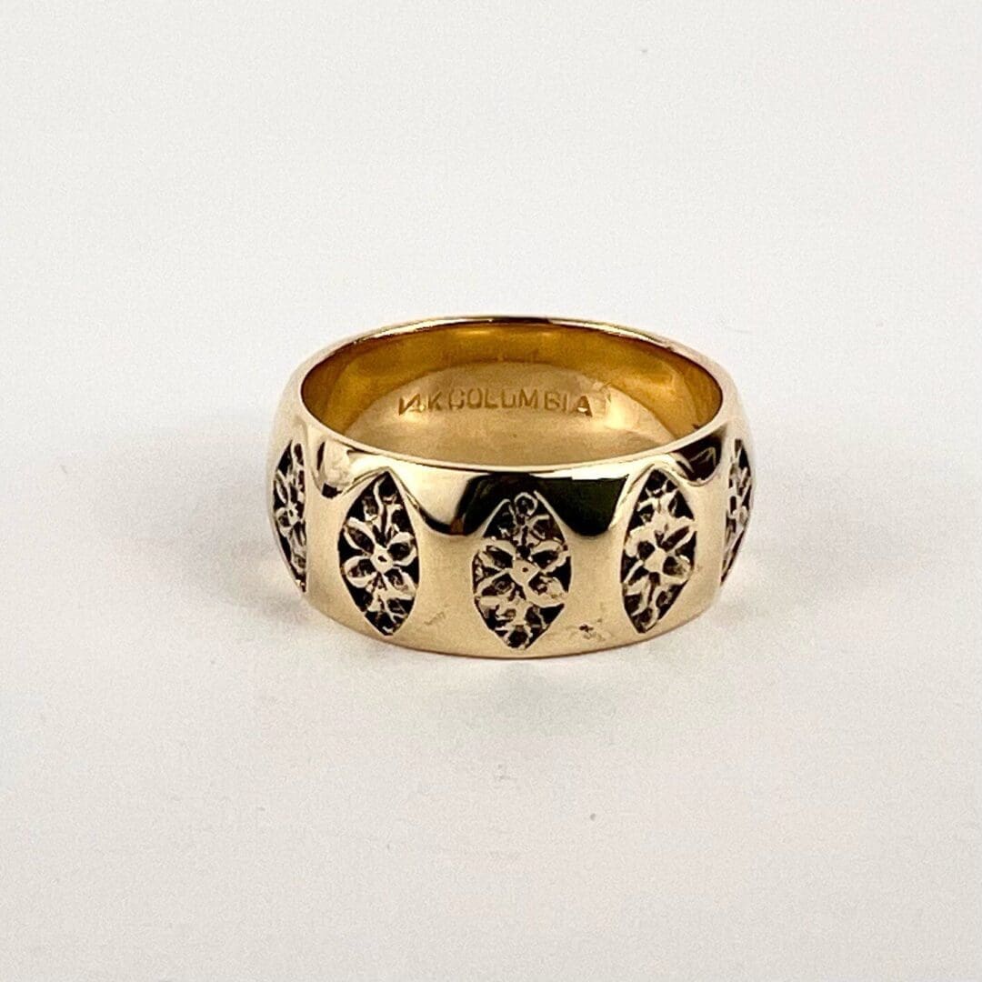 Gold ring with ornate black patterns.
