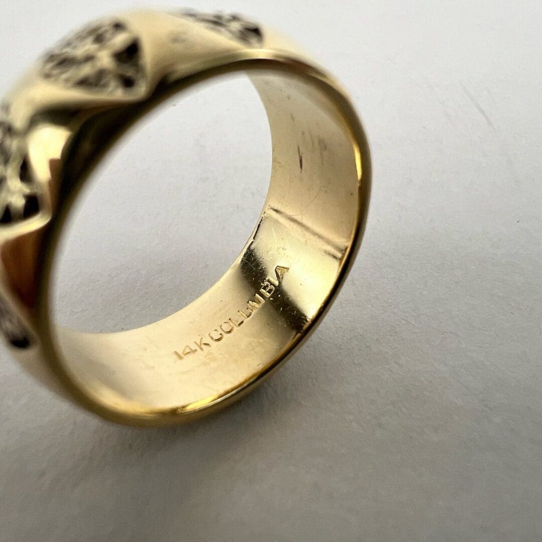 Gold ring with engraved patterns and hallmark.