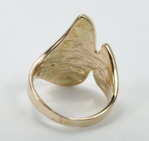 Gold abstract-shaped ring on white background.