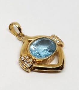 Gold pendant with blue gemstone and diamonds.