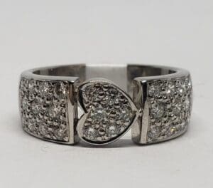 Silver ring with heart-shaped diamond centerpiece.