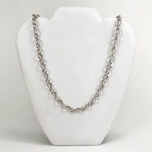 Silver chain necklace on display stand.