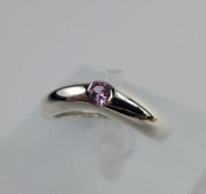 Silver ring with a purple gemstone.