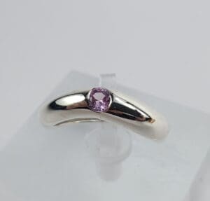 Silver ring with a purple gemstone.