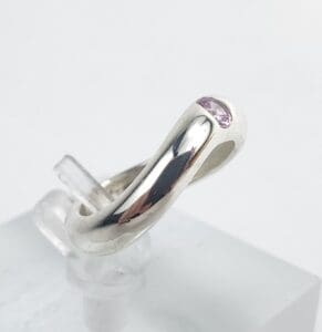 Silver ring with small purple gemstone.