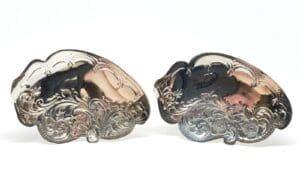 Ornate silver belt buckles with intricate designs.