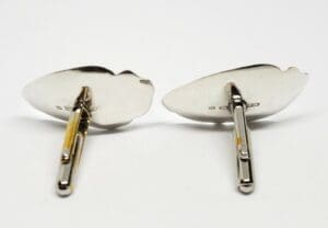 Silver cufflinks with engraved details, back view.