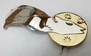 Metal brooch with fox design and flowers.