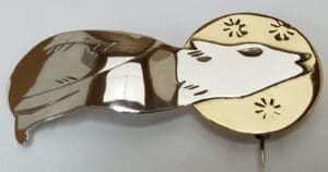 Wolf brooch with moon and stars design.