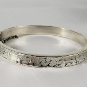 Silver engraved bracelet with geometric patterns.