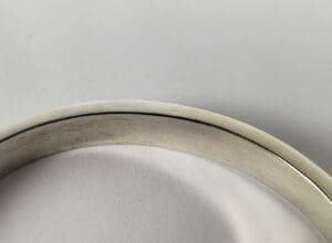 Silver and white bangle on white background.