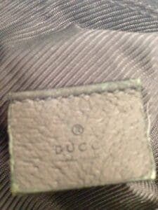 Leather tag with embossed text on fabric.