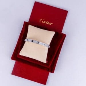 Silver bracelet on red Cartier packaging.