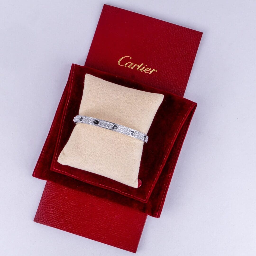 Silver bracelet on red Cartier packaging.