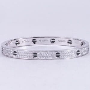 Silver bracelet with diamond accents and screws.