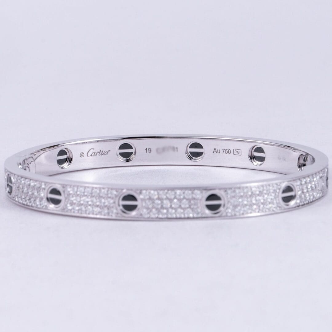 Silver bracelet with diamond accents and screws.