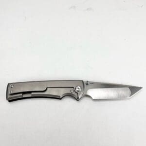 Folding knife with a sleek metallic design.