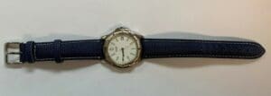 Wristwatch with navy blue strap on display.