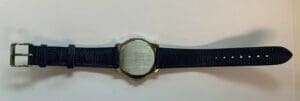 Wristwatch with blue strap on white background.