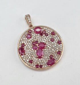 Gold pendant with pink and white stones.