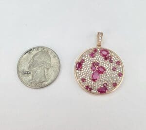 Ruby pendant next to a quarter coin.