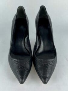 Black embossed high-heeled shoes, pointed toes.