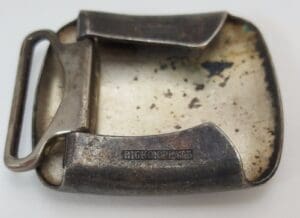 Vintage metal belt buckle, slightly tarnished surface.