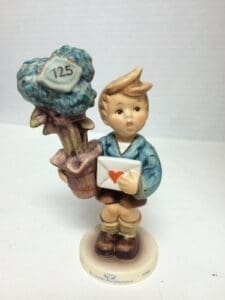 Boy figurine with heart letter and tree.
