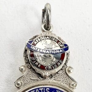 Silver International Fire Chiefs Association pendant.