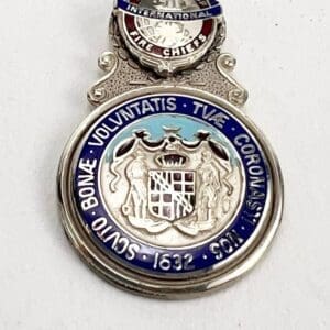 Silver medal with intricate engraved design.