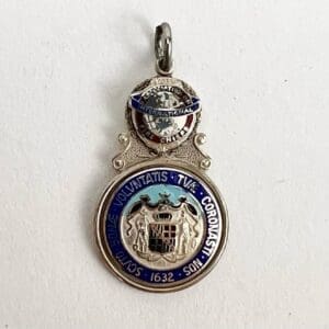 Silver and blue vintage medallion with inscriptions.