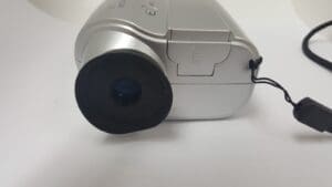 Silver digital camera with lens cap attached.