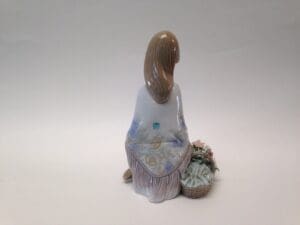 Ceramic figurine of a woman with basket.