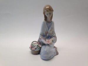 Porcelain figurine with basket of flowers.