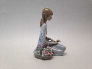 Figurine of woman with flower basket.